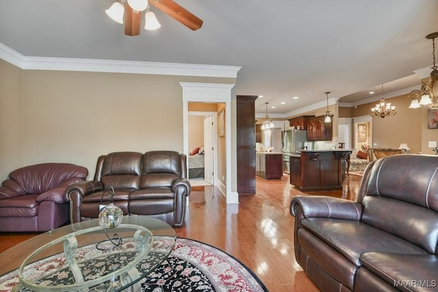living area featuring ceiling fan, ornamental molding, light wood finished floors, a chandelier, and recessed lighting