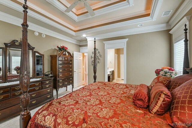 bedroom with crown molding, a tray ceiling, and a ceiling fan
