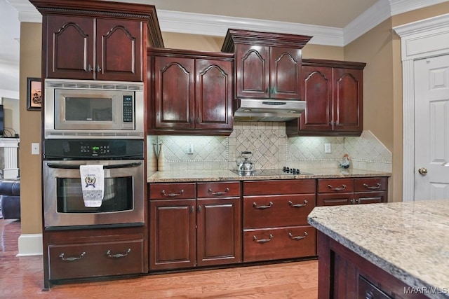 kitchen featuring appliances with stainless steel finishes, under cabinet range hood, ornamental molding, tasteful backsplash, and light stone counters