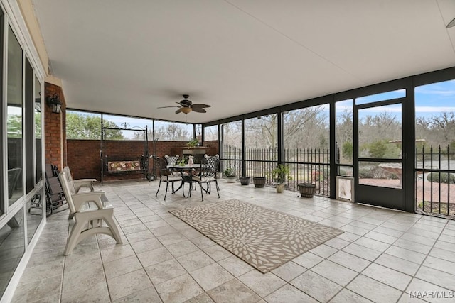 sunroom with outdoor dining area and ceiling fan