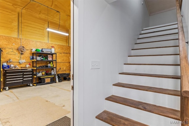 stairway with concrete floors and a workshop area