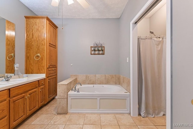 bathroom featuring a garden tub, vanity, a textured ceiling, and tile patterned floors