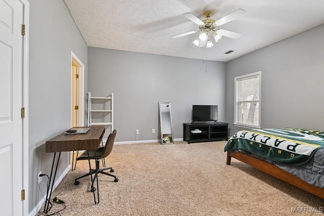 carpeted bedroom with a ceiling fan, baseboards, visible vents, and a textured ceiling