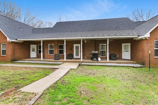 ranch-style house featuring brick siding, a patio, and roof with shingles