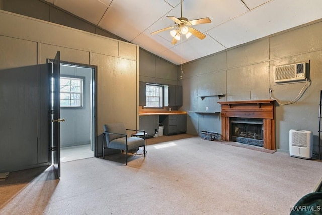 living room with a healthy amount of sunlight, vaulted ceiling, light colored carpet, and a wall mounted air conditioner