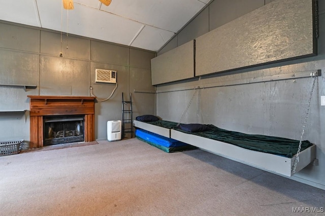 interior space featuring lofted ceiling, a wall mounted AC, a fireplace, and light colored carpet