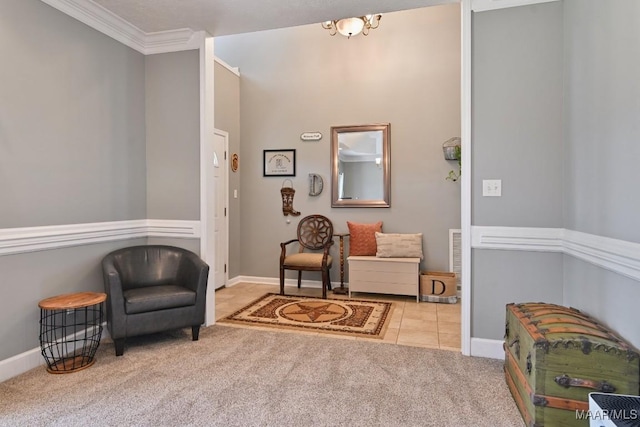 living area with light carpet, ornamental molding, light tile patterned flooring, and baseboards