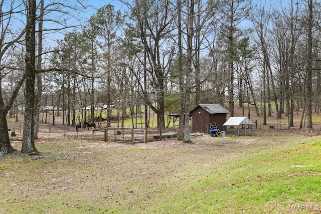 view of yard with an outbuilding, a rural view, fence, and a garage