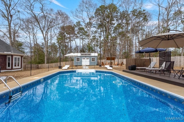 view of swimming pool featuring a fenced in pool, a patio, a fenced backyard, an exterior structure, and an outdoor structure