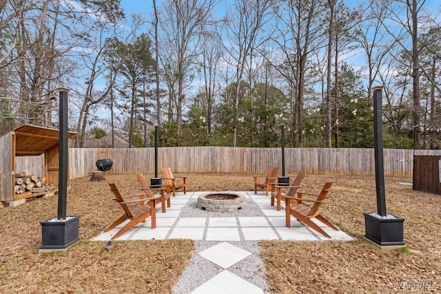 view of yard featuring a fire pit, a patio area, and a fenced backyard