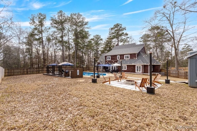 view of yard with a fenced in pool, an outdoor fire pit, a patio area, and a fenced backyard