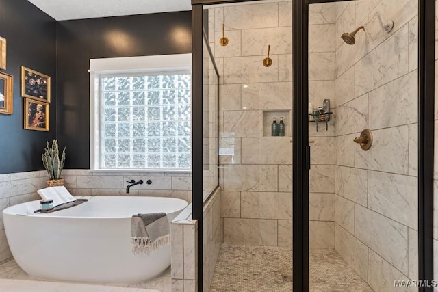 bathroom featuring a stall shower and a freestanding tub