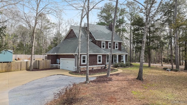 view of front facade with driveway, a garage, a shingled roof, a chimney, and fence