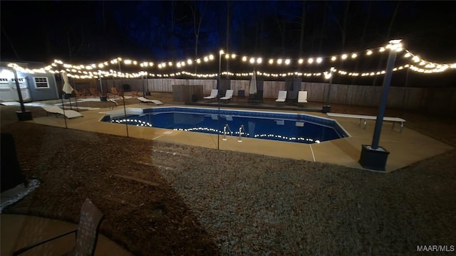 pool at twilight with a fenced in pool, a patio area, and a fenced backyard