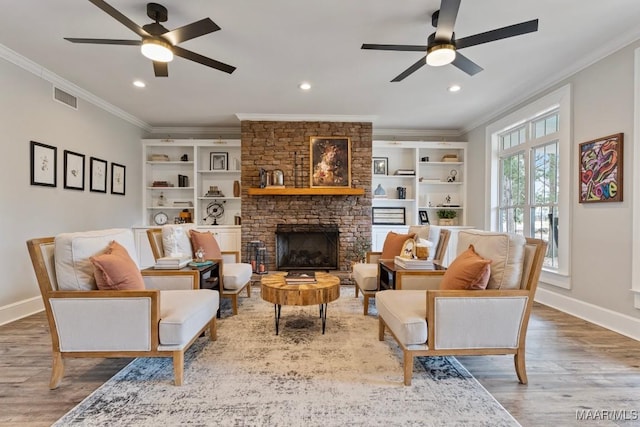 living area with wood finished floors, visible vents, and crown molding