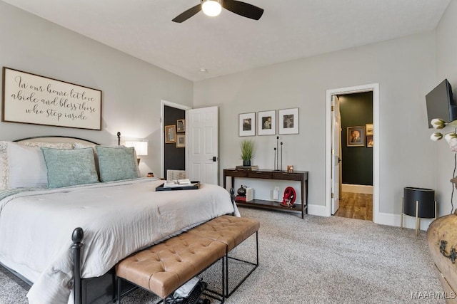 carpeted bedroom with ceiling fan and baseboards