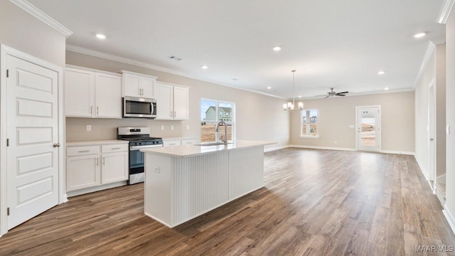 kitchen with a kitchen island with sink, stainless steel appliances, white cabinetry, open floor plan, and light countertops