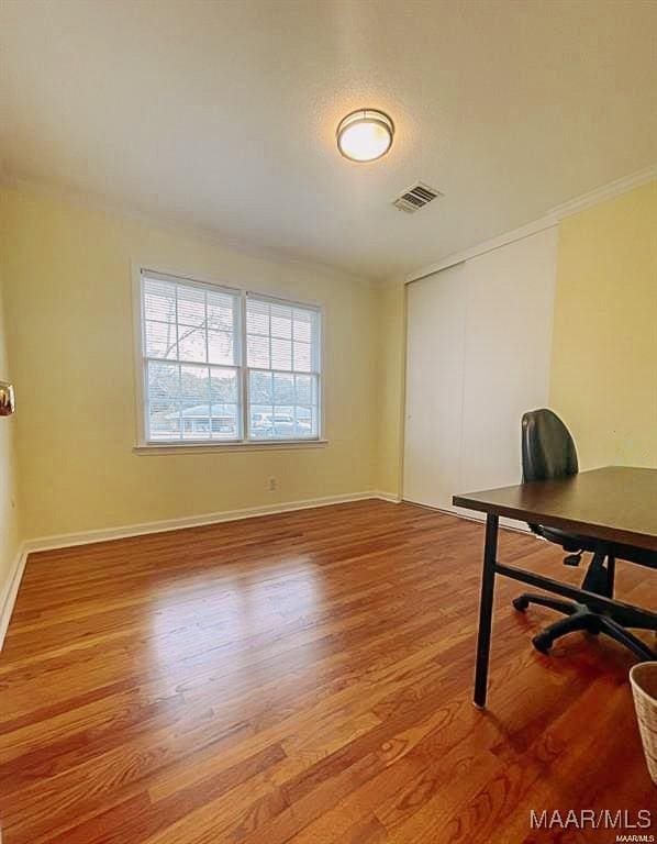 office area featuring visible vents, crown molding, light wood-style flooring, and baseboards