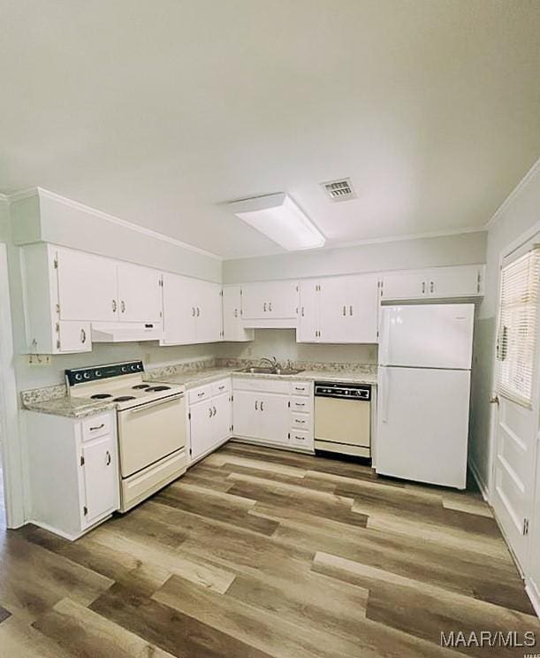 kitchen featuring white appliances, light countertops, and white cabinets