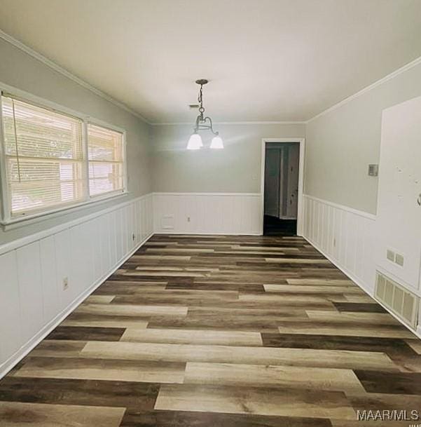 unfurnished dining area with an inviting chandelier, visible vents, dark wood finished floors, and wainscoting