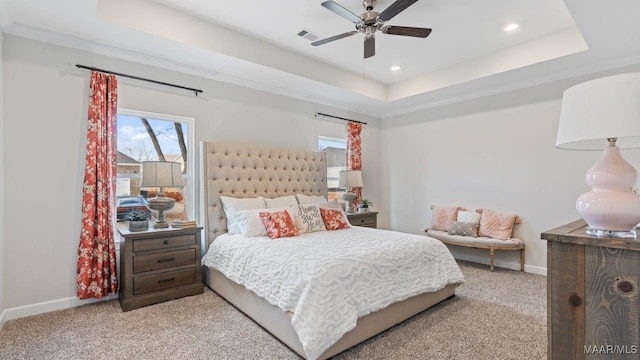 bedroom with baseboards, a tray ceiling, multiple windows, and visible vents