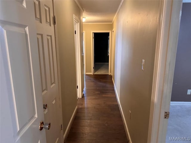 corridor featuring ornamental molding, dark wood-style flooring, and baseboards