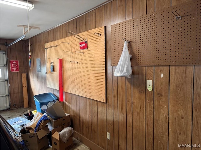 misc room with a garage and wooden walls