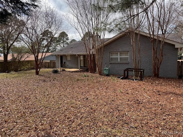 back of house with fence and brick siding