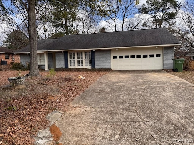 ranch-style home featuring a garage, driveway, and brick siding