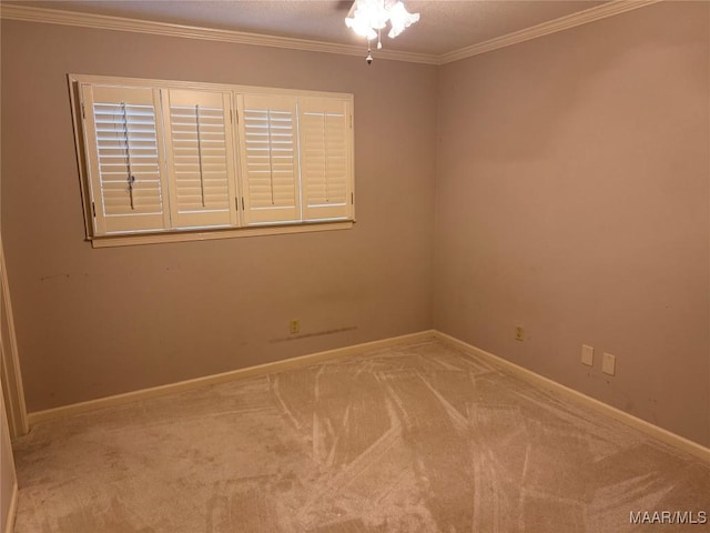 carpeted spare room with ornamental molding and baseboards