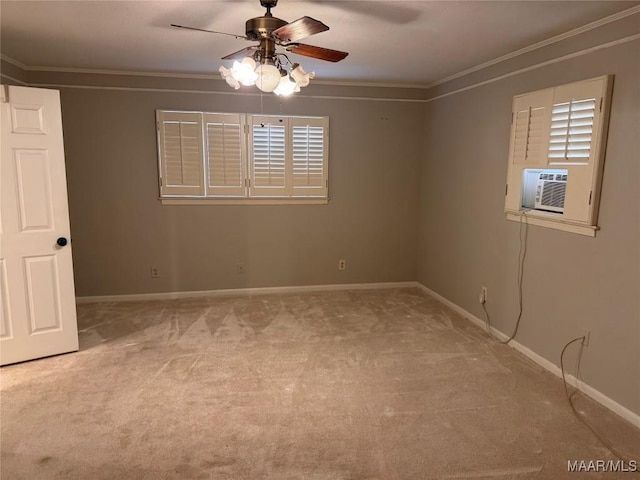 spare room featuring light colored carpet, ornamental molding, a ceiling fan, cooling unit, and baseboards