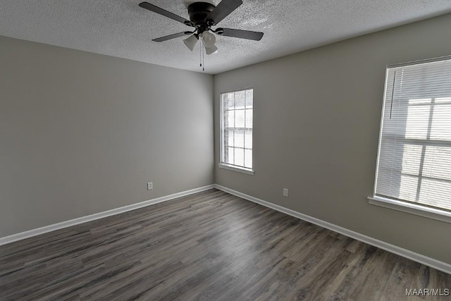 spare room featuring a ceiling fan, a textured ceiling, baseboards, and dark wood-type flooring