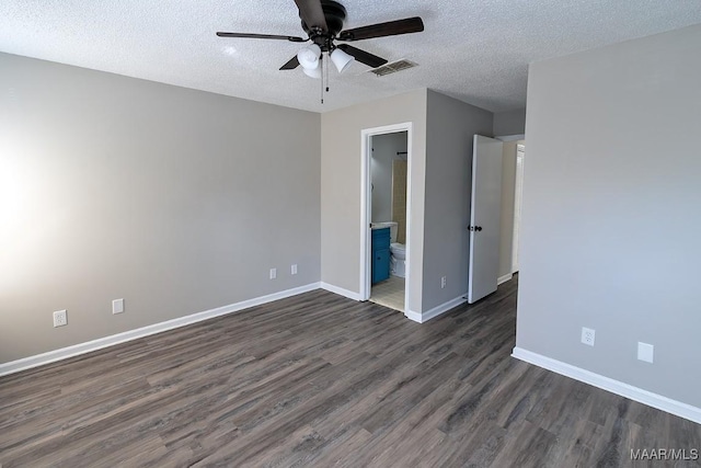 unfurnished bedroom with dark wood-style floors, visible vents, a textured ceiling, and baseboards