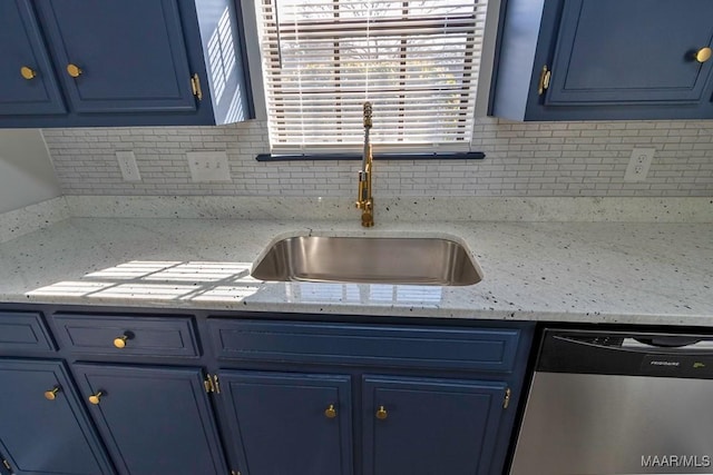 kitchen featuring blue cabinets, a sink, backsplash, and dishwasher