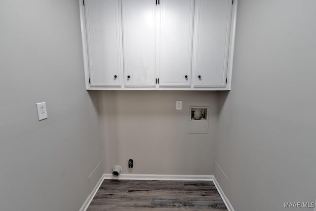 clothes washing area featuring dark wood-type flooring, washer hookup, cabinet space, and baseboards