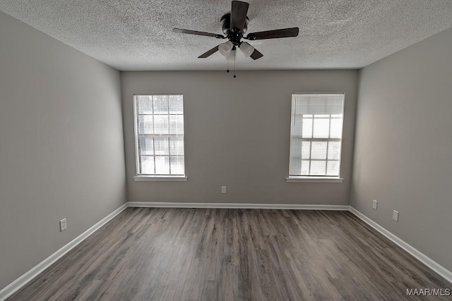 empty room with dark wood-style floors, ceiling fan, and baseboards