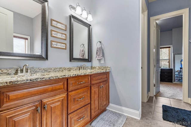 bathroom with tile patterned flooring, double vanity, baseboards, and a sink