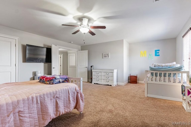 carpeted bedroom with a ceiling fan and baseboards