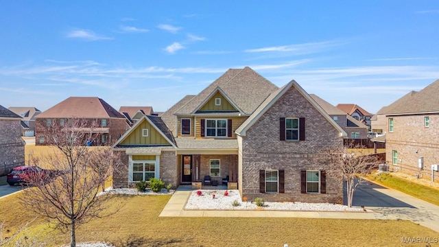 view of front of house featuring brick siding, board and batten siding, and a shingled roof