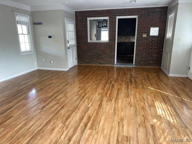 3110 Highfield Dr, Montgomery, AL 36111 - empty room featuring brick wall, light wood-style flooring, and baseboards