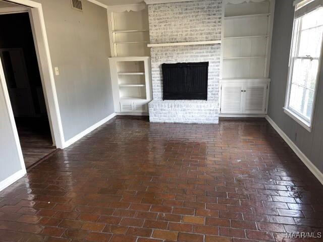 3110 Highfield Dr, Montgomery, AL 36111 - unfurnished living room featuring a wealth of natural light, a brick fireplace, and baseboards