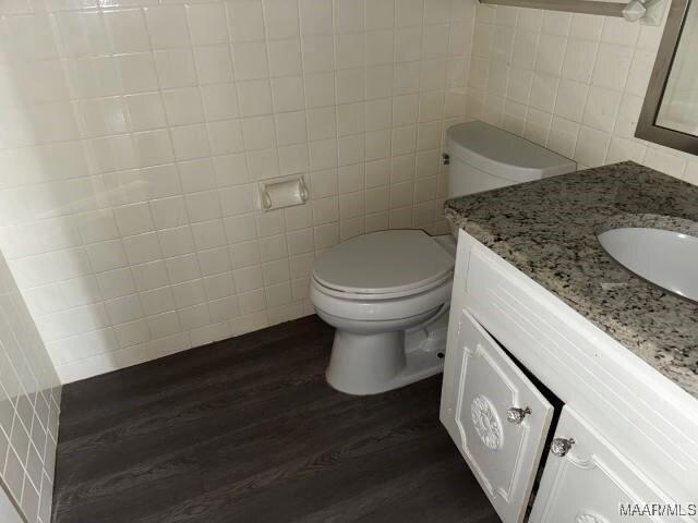 3110 Highfield Dr, Montgomery, AL 36111 - bathroom featuring toilet, tile walls, vanity, and wood finished floors