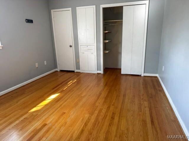 3110 Highfield Dr, Montgomery, AL 36111 - unfurnished bedroom with multiple closets, wood finished floors, and baseboards