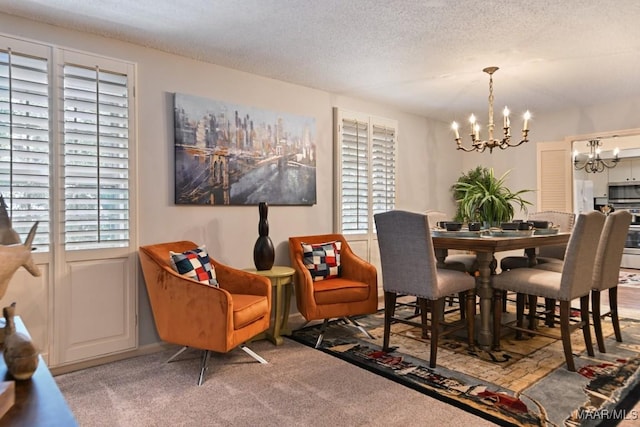 dining area with light colored carpet, a textured ceiling, and an inviting chandelier