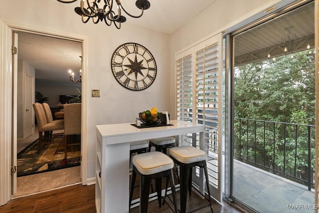 dining area featuring a chandelier, dark wood-type flooring, and a healthy amount of sunlight