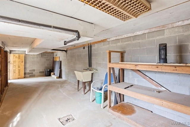 unfinished below grade area with a sink and concrete block wall