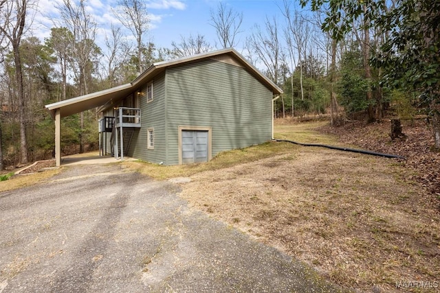 view of home's exterior with driveway and a carport