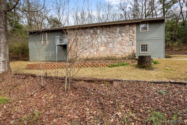 view of side of property with cooling unit and stone siding