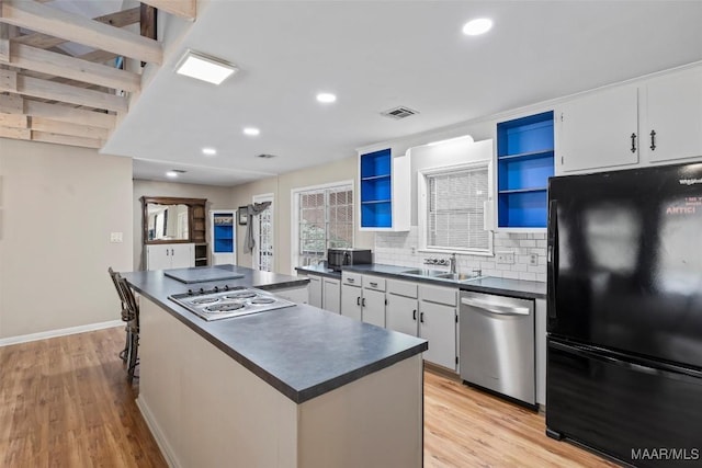 kitchen featuring open shelves, a kitchen island, white cabinets, black appliances, and dark countertops