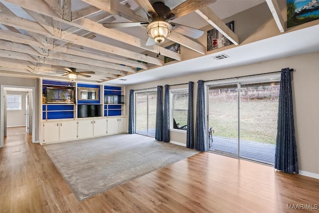 unfurnished living room featuring light wood-style flooring, visible vents, ceiling fan, and beamed ceiling